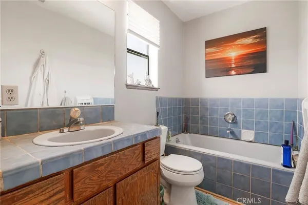 a bathroom with a granite countertop sink mirror vanity and toilet