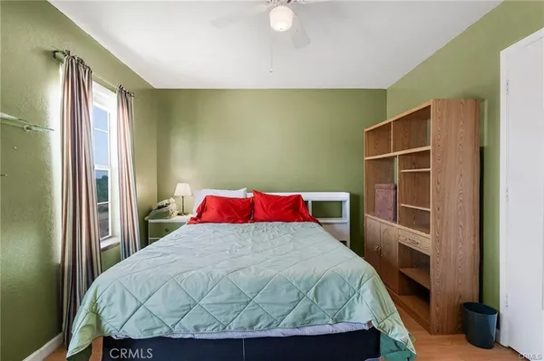 a bedroom with a bed and wooden floor