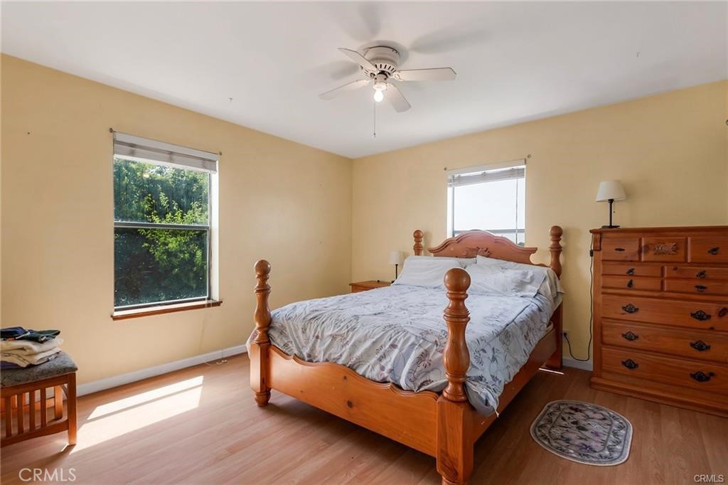22085 Finnell Avenue Corning, CA 96021 - Photo 32 of 68 a bedroom with a bed and a dresser with wooden floor