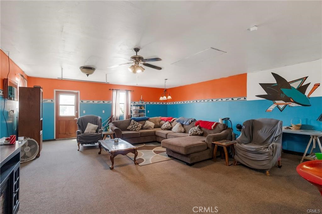 22085 Finnell Avenue Corning, CA 96021 - Photo 37 of 68 a living room with furniture a chandelier and a floor to ceiling window