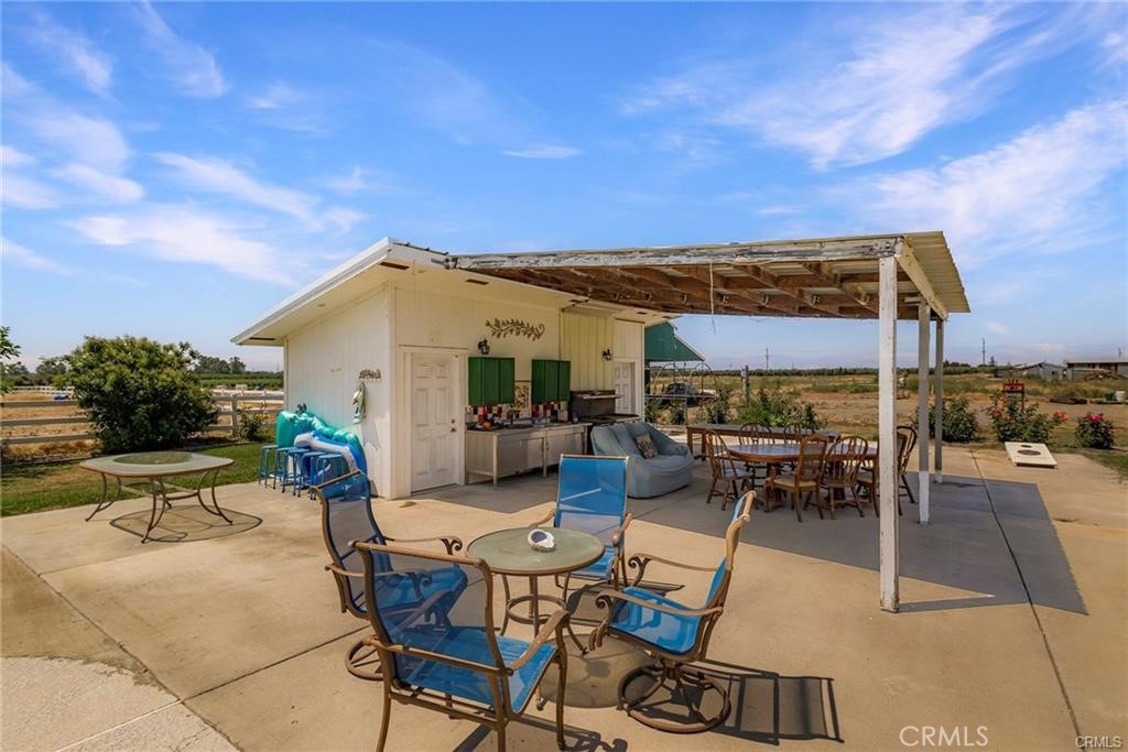 22085 Finnell Avenue Corning, CA 96021 - Photo 42 of 68 a view of a patio with table and chairs under an umbrella next to a yard