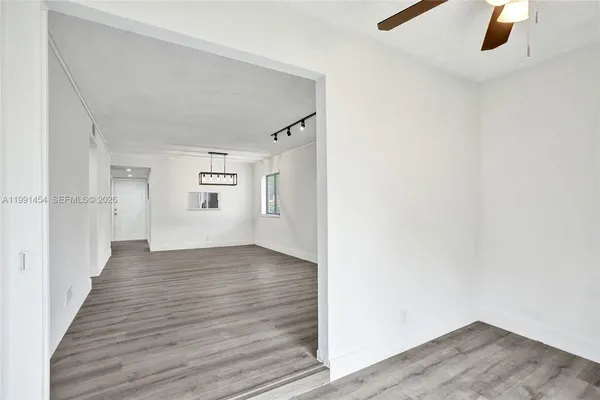 a view of a hallway with wooden floor