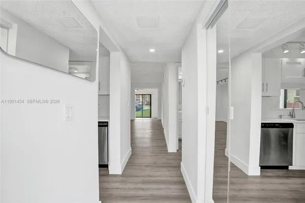 a view of a hallway with wooden floor and staircase