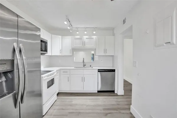 a kitchen with stainless steel appliances granite countertop a refrigerator sink and stove