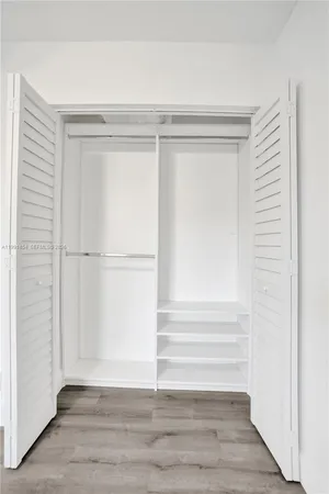 a view of walk in closet with empty racks