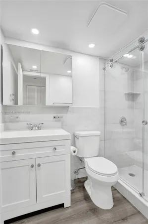 a bathroom with a sink a toilet and shower