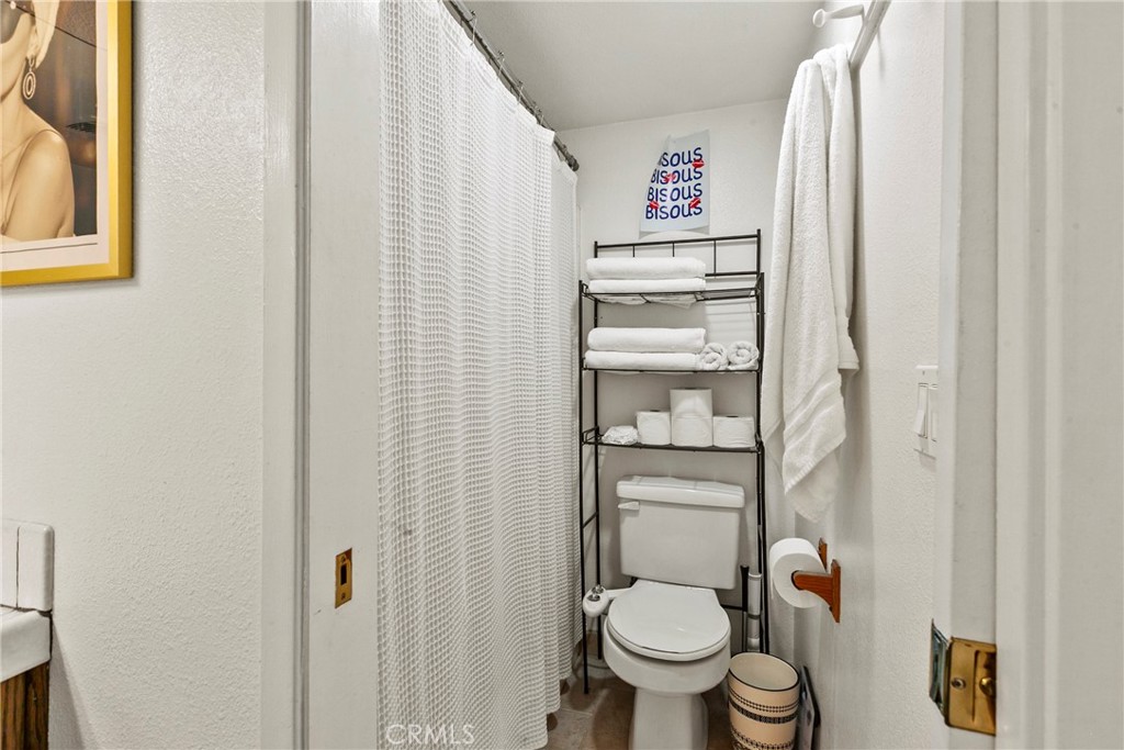 282 Robles Road, Unit 19 Arroyo Grande, CA 93420 - Photo 14 of 24 a bathroom with a toilet and a shower curtain