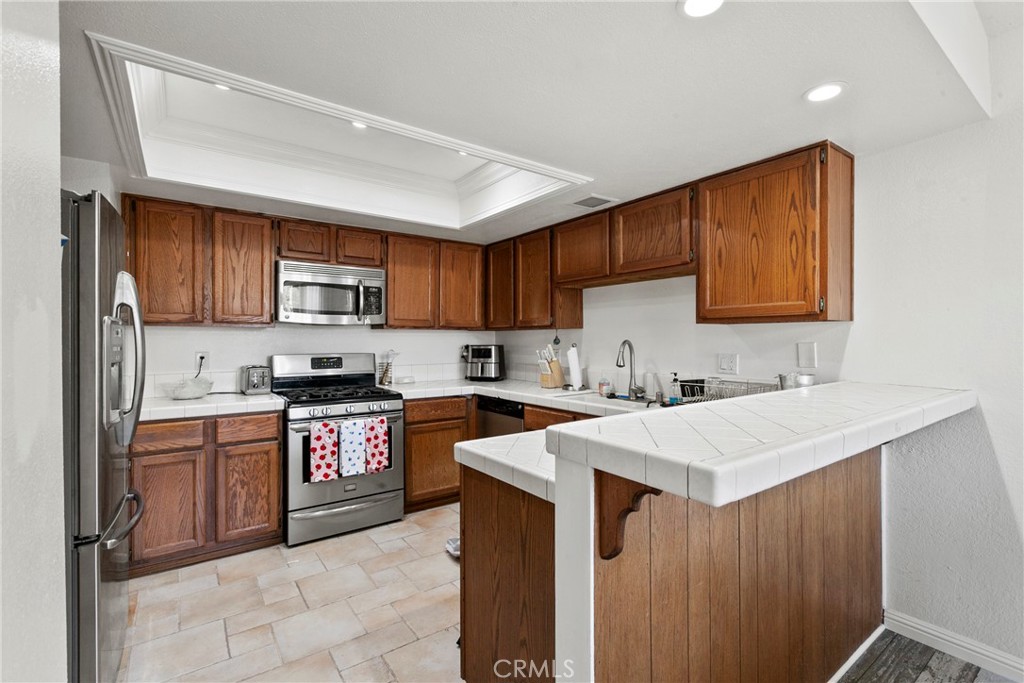 282 Robles Road, Unit 19 Arroyo Grande, CA 93420 - Photo 6 of 24 a kitchen with stainless steel appliances granite countertop a sink stove refrigerator and a microwave