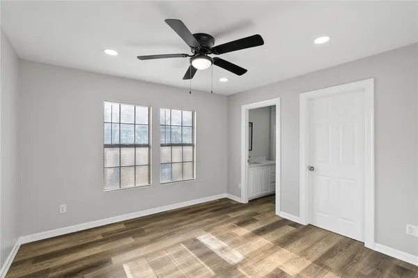 a view of an empty room and window and a ceiling fan