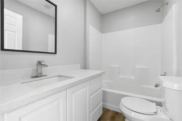 a bathroom with a granite countertop toilet sink and mirror