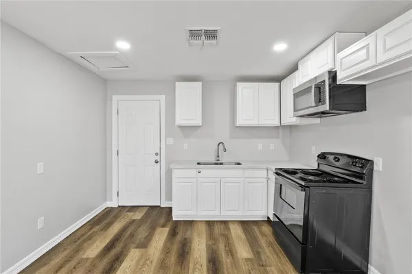 a kitchen with stainless steel appliances a stove a sink and a microwave