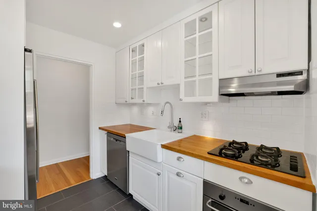 a kitchen with stainless steel appliances a white stove top oven and cabinets