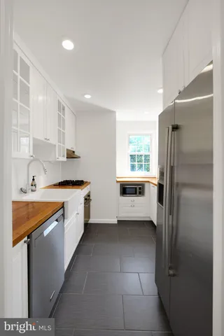 a kitchen with stainless steel appliances a refrigerator sink and cabinets