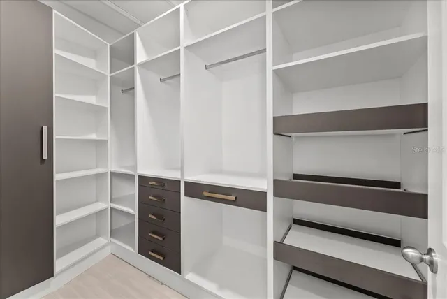 a view of walk in closet with empty racks