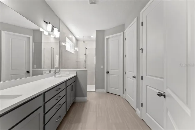 a spacious bathroom with a double vanity sink mirror and shower