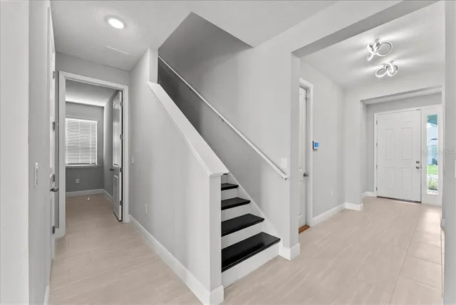 wooden floor in an empty room with a bathroom and a mirror
