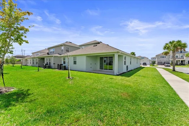 a yellow house with a big yard and big trees with a big yard