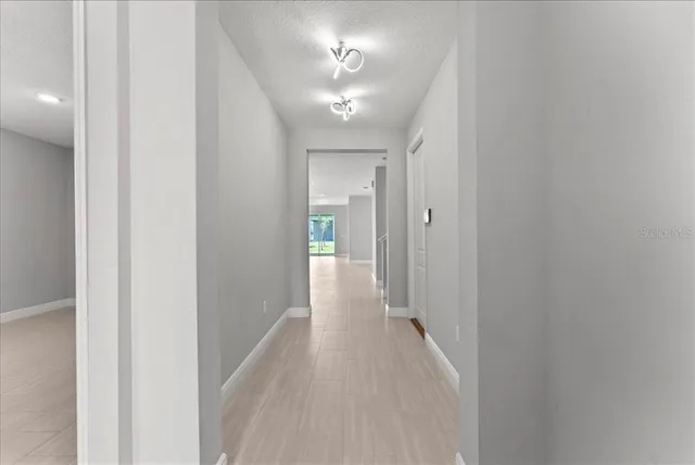 a view of a hallway with a chandelier fan