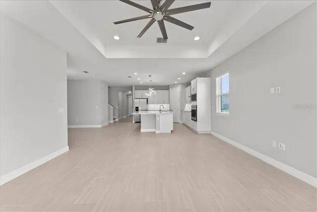 a view of a livingroom with a chandelier fan and furniture