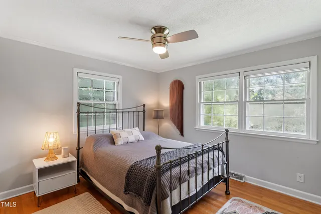 a view of a house with a yard and large trees