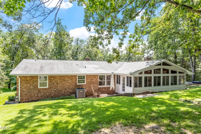 an aerial view of residential house with outdoor space and trees all around