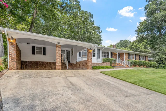 a front view of a house with a yard and trees