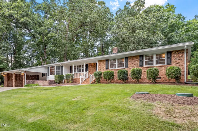 a front view of a house with a yard and trees