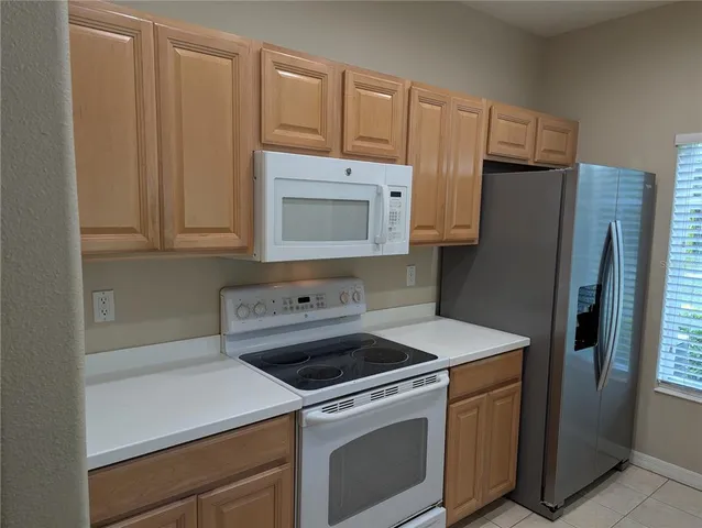 a kitchen that has a sink stove top oven and cabinets