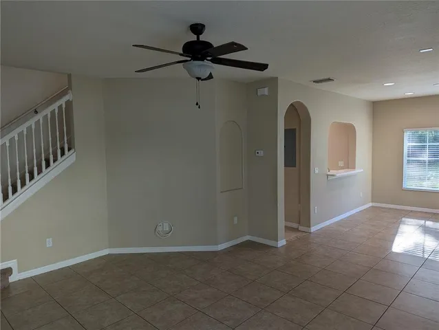 a view of hallway with a chandelier fan and windows