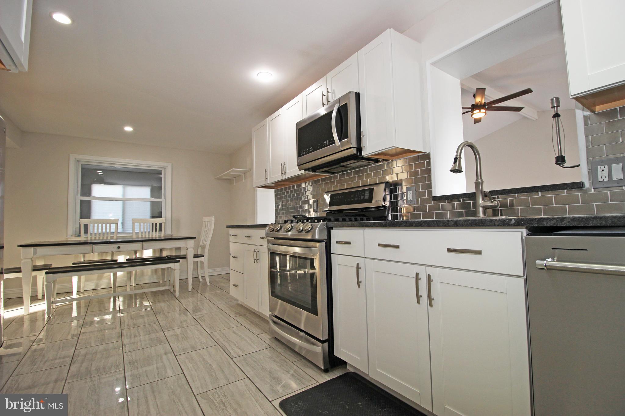 2748 Springhill Road Secane, PA 19018 - Photo 15 of 90 a kitchen with stainless steel appliances granite countertop a stove a sink and a microwave