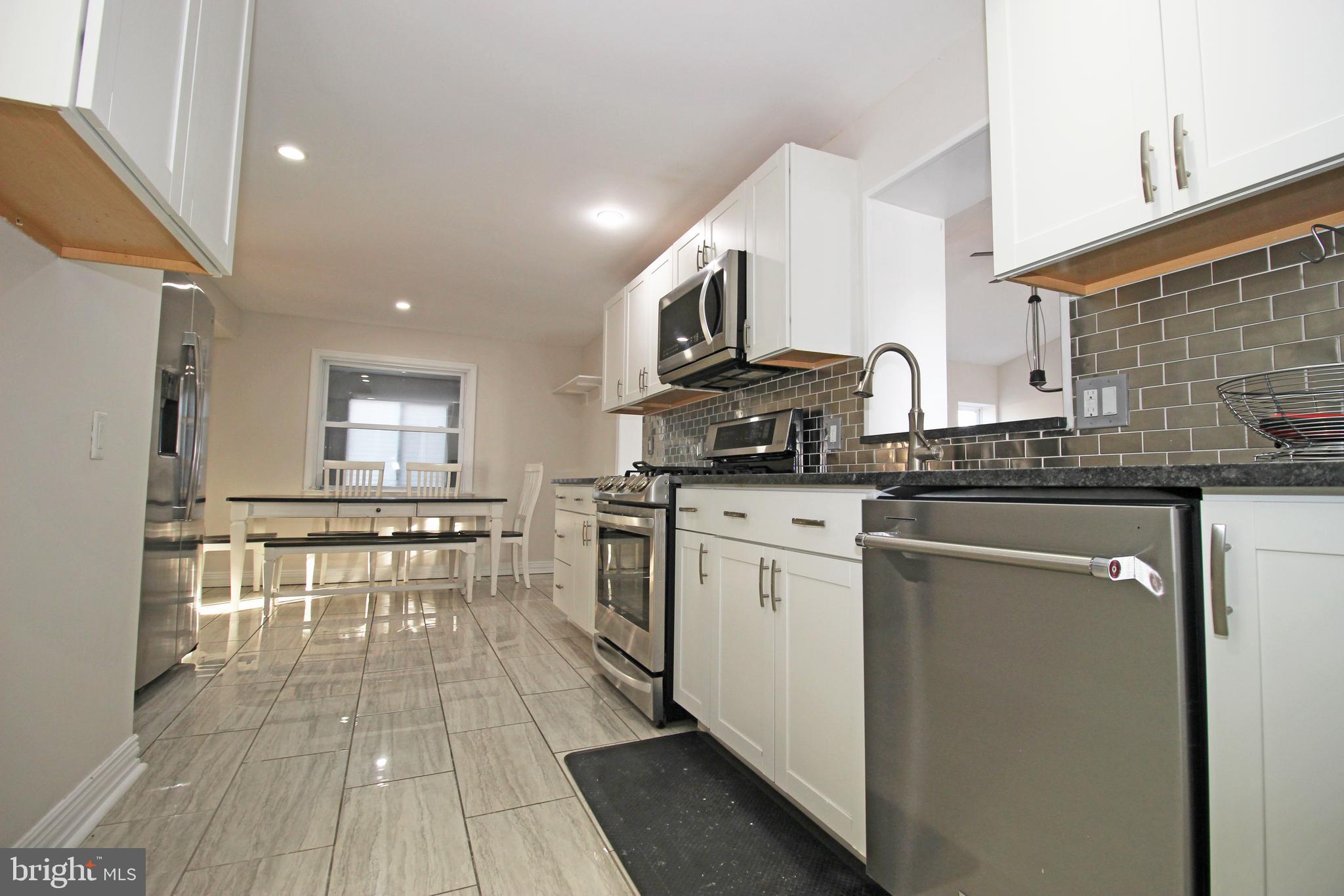 2748 Springhill Road Secane, PA 19018 - Photo 24 of 90 a kitchen with stainless steel appliances granite countertop a stove a sink dishwasher and a refrigerator with wooden floor