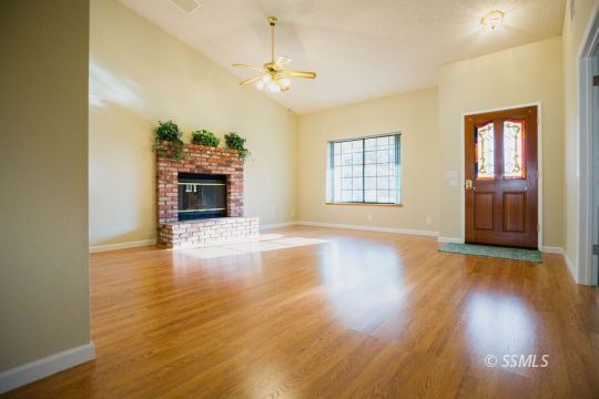 608 Amanda Street Ridgecrest, CA 93555 - Photo 9 of 30 a view of a livingroom with a fireplace wooden floor and window