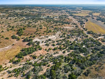 an aerial view of residential houses with outdoor space and trees