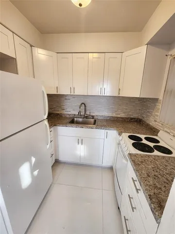 a kitchen with a sink a stove and cabinets