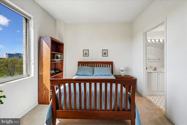a bed sitting in a bedroom next to a bathroom sink