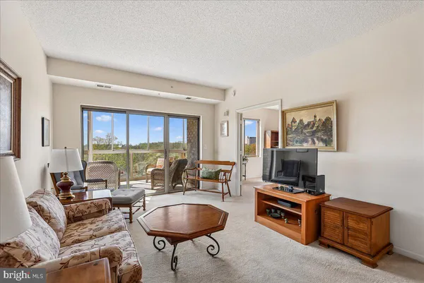 a living room with furniture and floor to ceiling windows