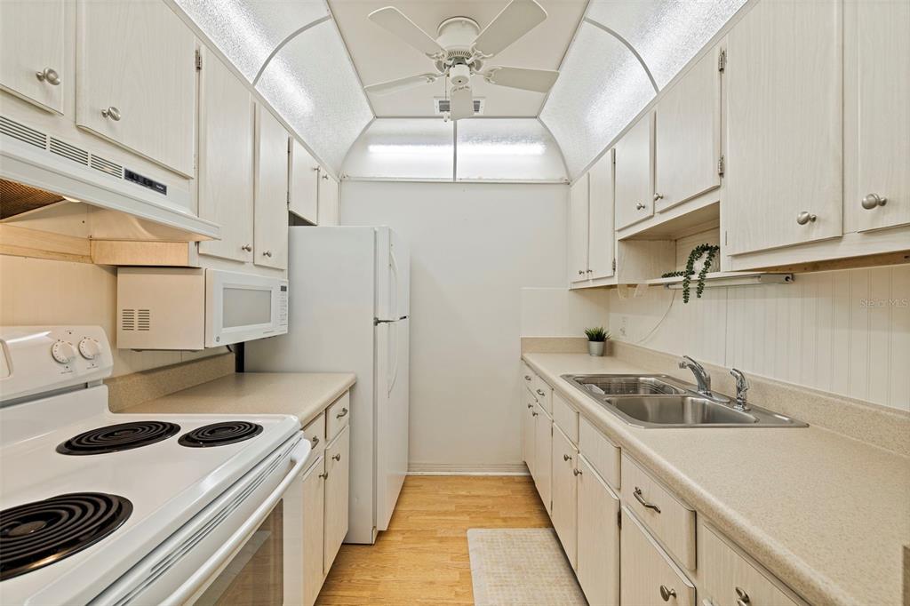 8221 112th Street North, Unit 203 Seminole, FL 33772 - Photo 13 of 31 a kitchen with stainless steel appliances granite countertop a sink stove and refrigerator