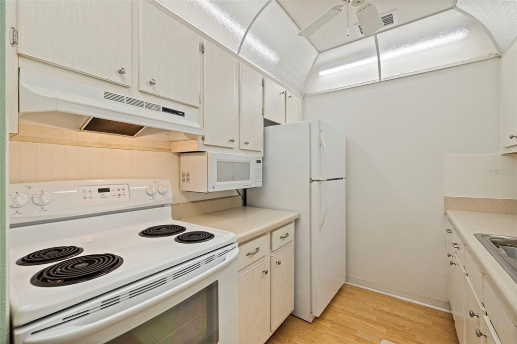 8221 112th Street North, Unit 203 Seminole, FL 33772 - Photo 14 of 31 a kitchen with a refrigerator and white stove