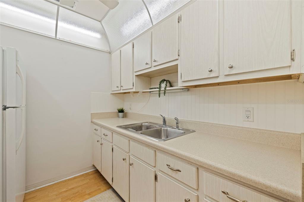 8221 112th Street North, Unit 203 Seminole, FL 33772 - Photo 15 of 31 a kitchen with white cabinets and sink
