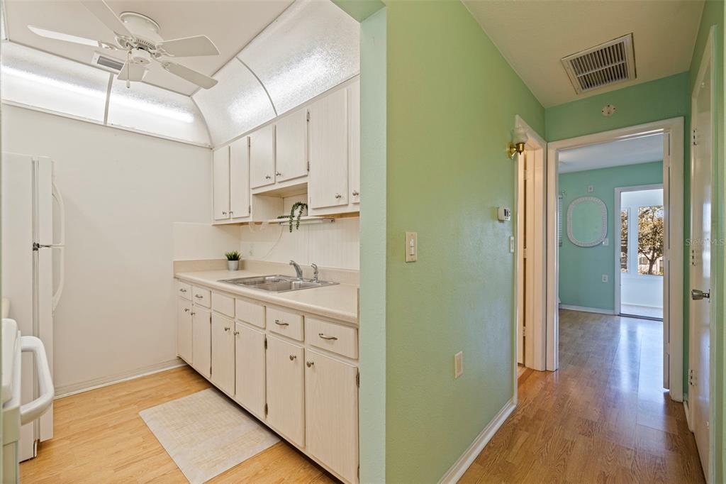 8221 112th Street North, Unit 203 Seminole, FL 33772 - Photo 17 of 31 a kitchen with cabinets and wooden floor