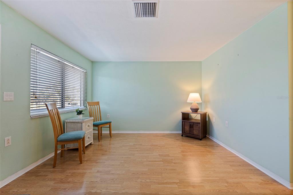 8221 112th Street North, Unit 203 Seminole, FL 33772 - Photo 9 of 31 a bedroom with a bed and a chair