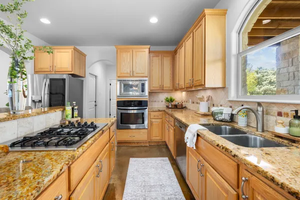 a kitchen with stainless steel appliances a stove sink and cabinets