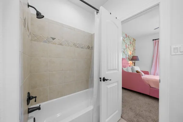 a bathroom with a tub shower and sink