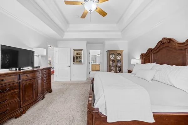 a large bedroom with a bed and a flat screen tv