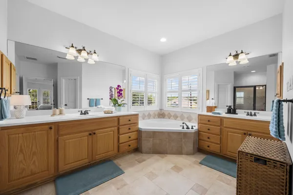 a large bathroom with a double vanity sink bathtub and next to a window