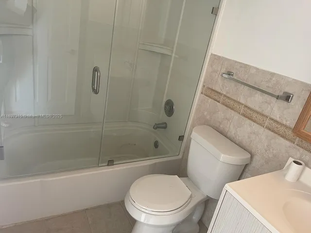 a white toilet and tub sitting next to a bathroom sink
