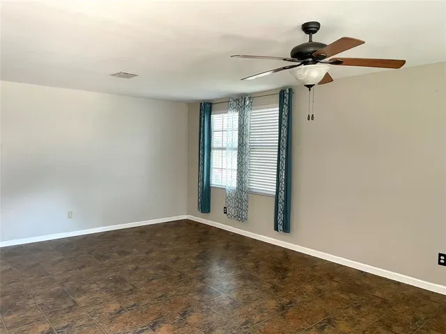 a view of a room with a ceiling fan and window
