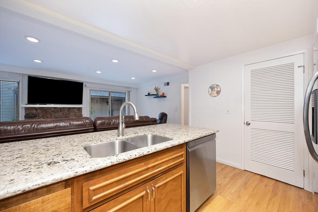 6902 Monticello Court Citrus Heights, CA 95621 - Photo 12 of 56 a view of a kitchen with kitchen island a sink wooden floor and a counter top space