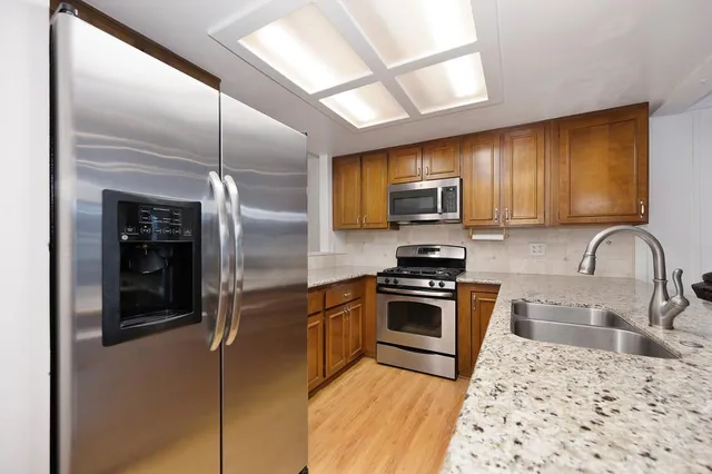 a kitchen with granite countertop counter top space cabinets and stainless steel appliances