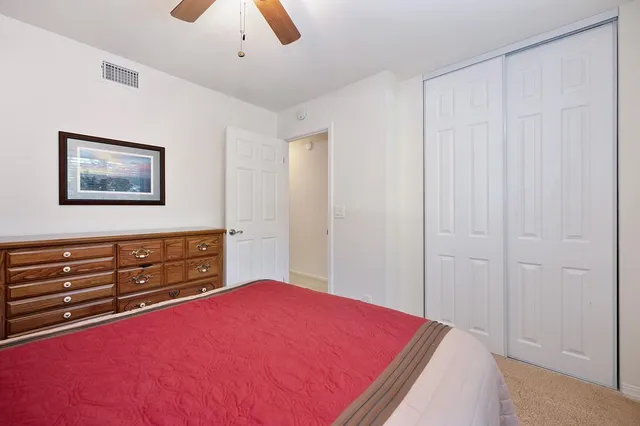 a bedroom with a bed and a ceiling fan